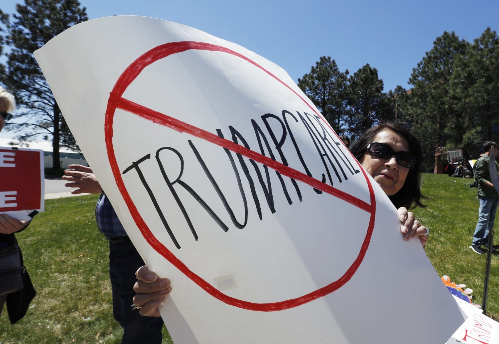 Rosie Bonger of Englewood, Colo., holds up a placard during a protest outside the office of U.S. Rep. Mike Coffman, R-Colo., in Aurora, Colo., over the health care bill passed by the U.S. House Thursday, May 4, 2017. (David Zalubowski/AP)