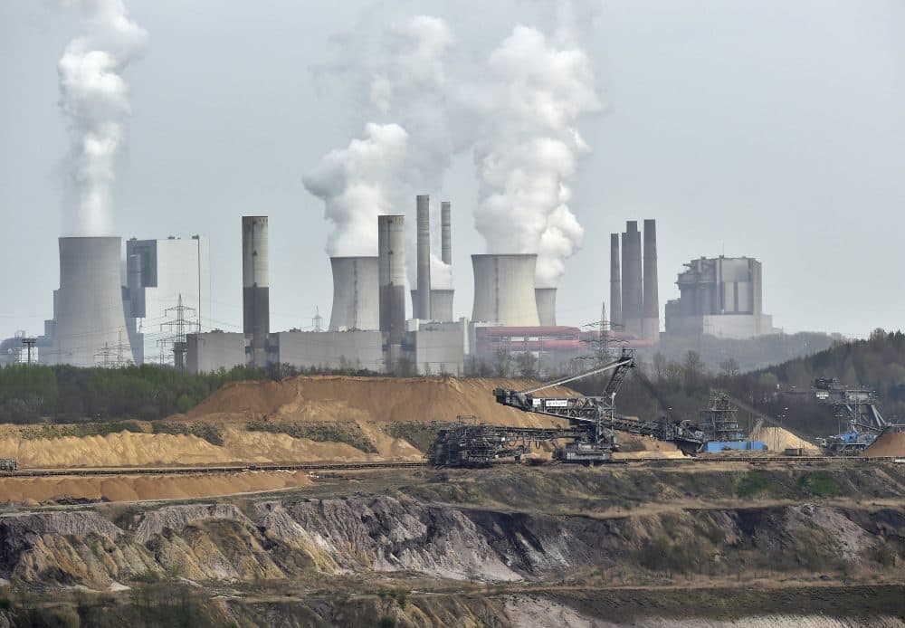 In this 2014 file photo, giant machines dig for brown coal at the open-cast mining Garzweiler in front of a smoking power plant near the city of Grevenbroich in western Germany. (Martin Meissner/AP)