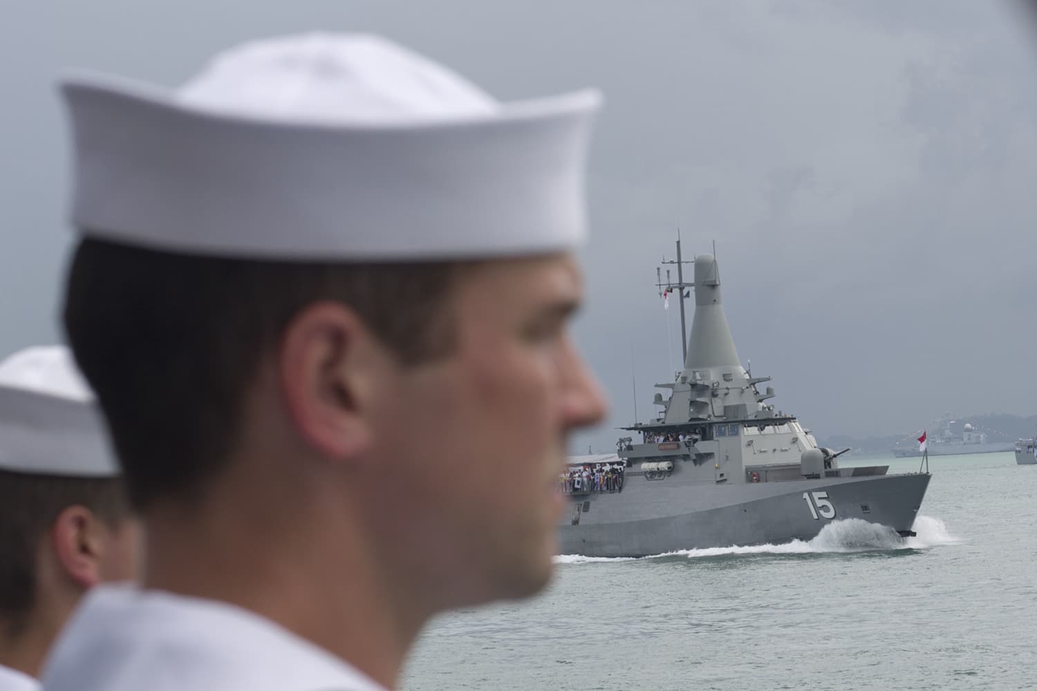 Sailors aboard the USS Sterett stand at attention as the reviewing ship passes during the International Maritime Review parade of ships off the coast of Singapore on May 15, 2017. (U.S. Navy photo by Mass Communication Specialist 1st Class Byron C. Linder/Released)