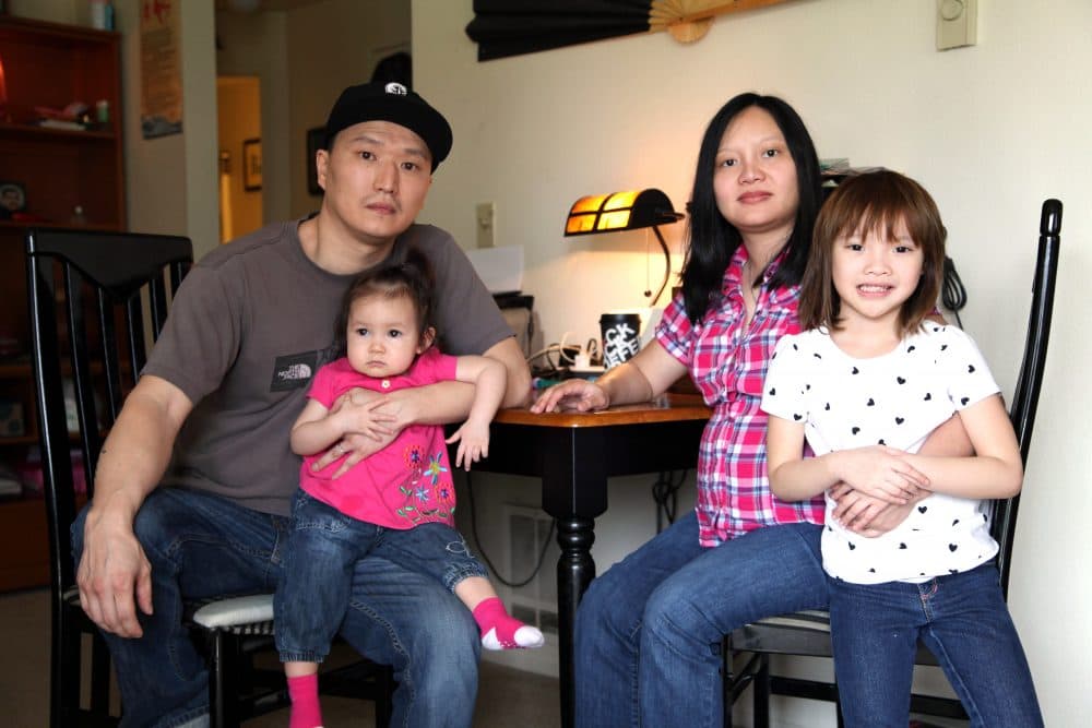 Korean adoptee Adam Crapser poses with his daughters and his wife, Anh Nguyen, in the family's living room in Vancouver, Wash. on March 19, 2015. (Gosia Wozniacka/AP)