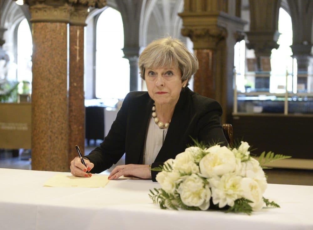 Britain's Prime Minister, Theresa May, writes a message at Manchester Town Hall, Tuesday May 23, 2017. (Ben Birchall/AP)