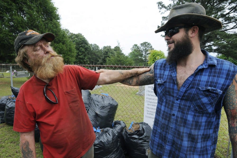 Jimmy Frank Hicks, left, and nephew Tyler Goodson of the hit podcast &quot;S-Town&quot; stand at the grave of friend John B. McLemore. (Jay Reeves/AP)