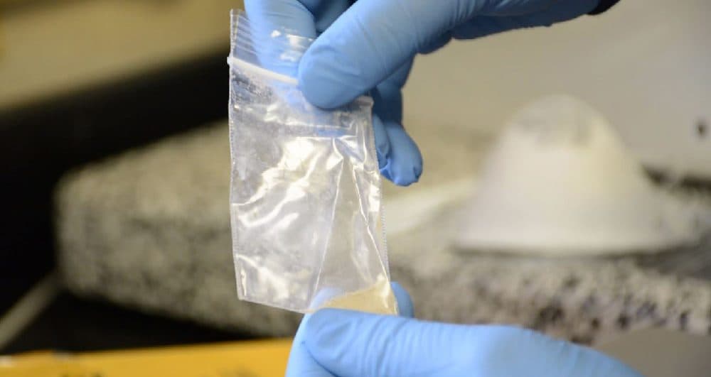 A forensic analyst at the Lake County Crime Laboratory handles a sample of fentanyl in powder form. (Nick Castele/WCPN ideastream)