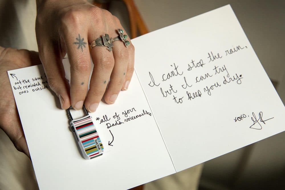 Alice Saunders holds the flash drive of her father's voicemail messages, and the note Greg Ralich wrote when he gave it to her. (Robin Lubbock/WBUR)