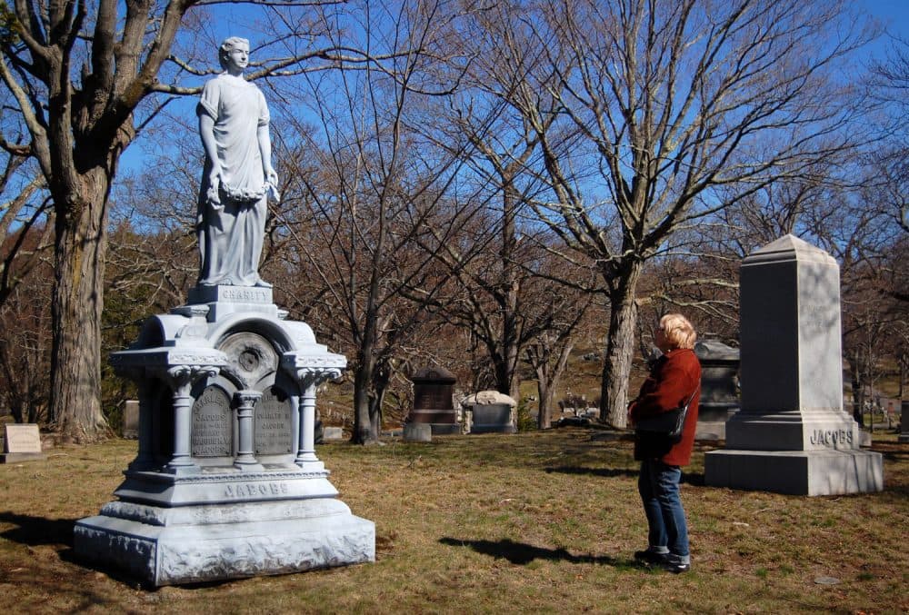 Dee Morris views the statue of Charity atop the Jacobs family grave at Medford's Oak Grove Cemetery. (Greg Cook/WBUR)