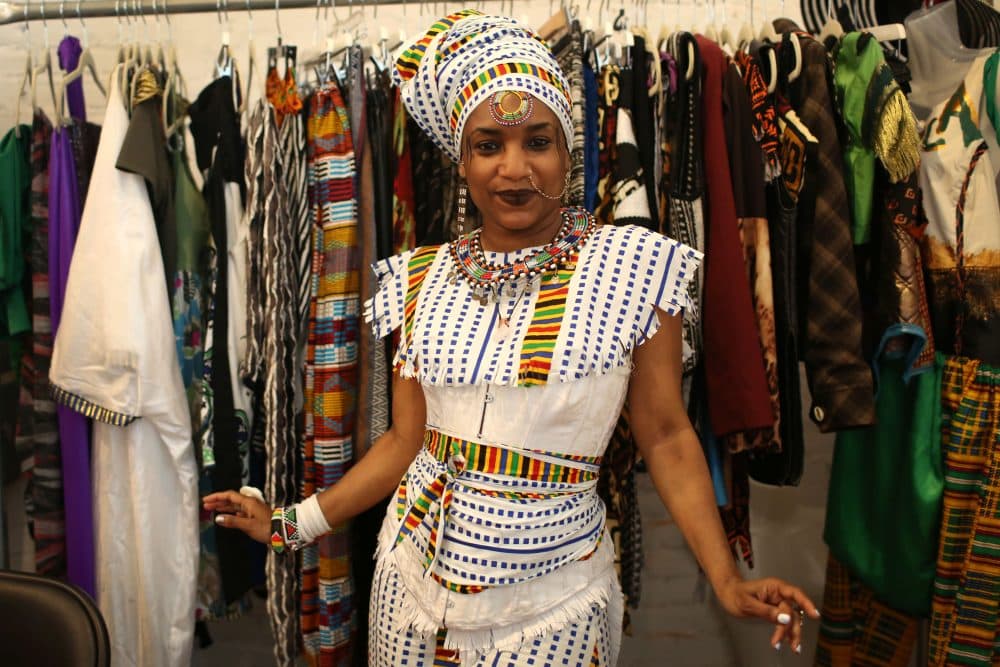 Nahdra Ra Kiros, owner of the clothing company The House of Nahdra, poses in front of her booth at Black Market last year. (Hadley Green for WBUR)