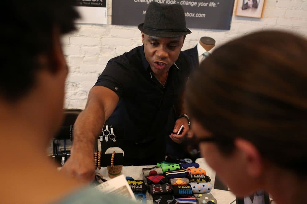 Lance McBrayer talks to shoppers at his retail space at Black Market. (Hadley Green for WBUR)