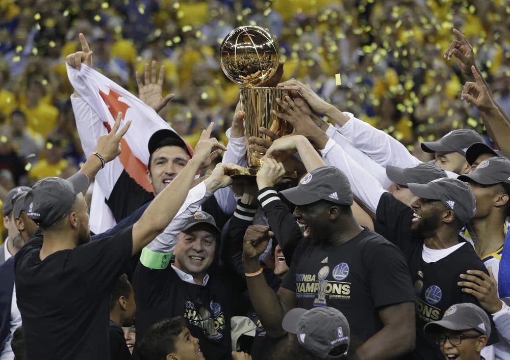 Golden State Warriors players, coaches and owners hold up the Larry O'Brien NBA Championship Trophy after Game 5 of basketball's NBA Finals between the Warriors and the Cleveland Cavaliers in Oakland, Calif., Monday, June 12, 2017. (Marcio Jose Sanchez/AP)