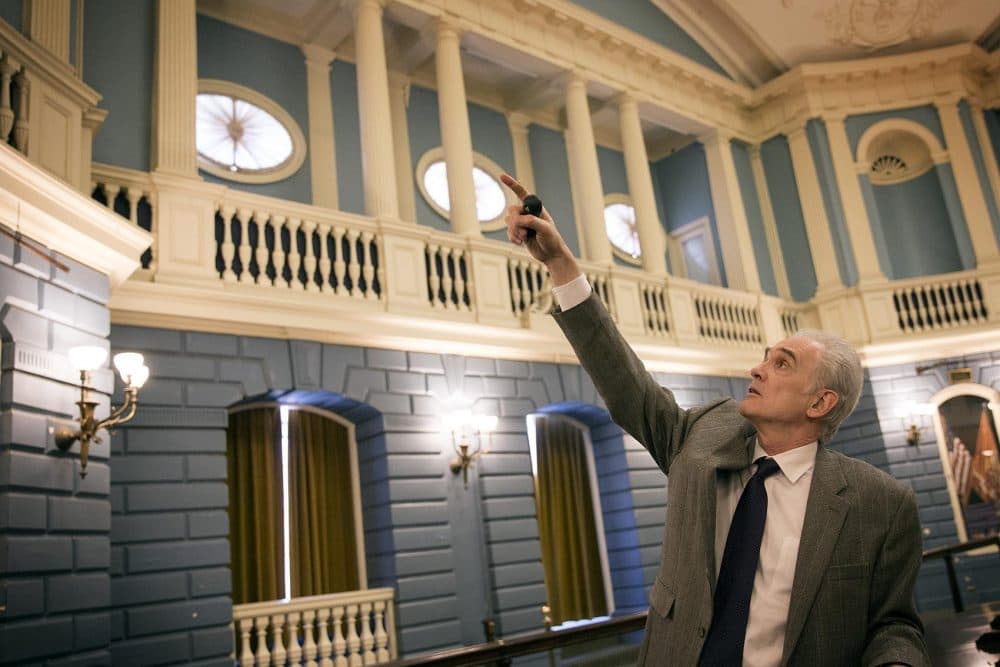 Architect Christos Coios points at areas in need of repair in the State House Senate chamber. (Robin Lubbock/WBUR)