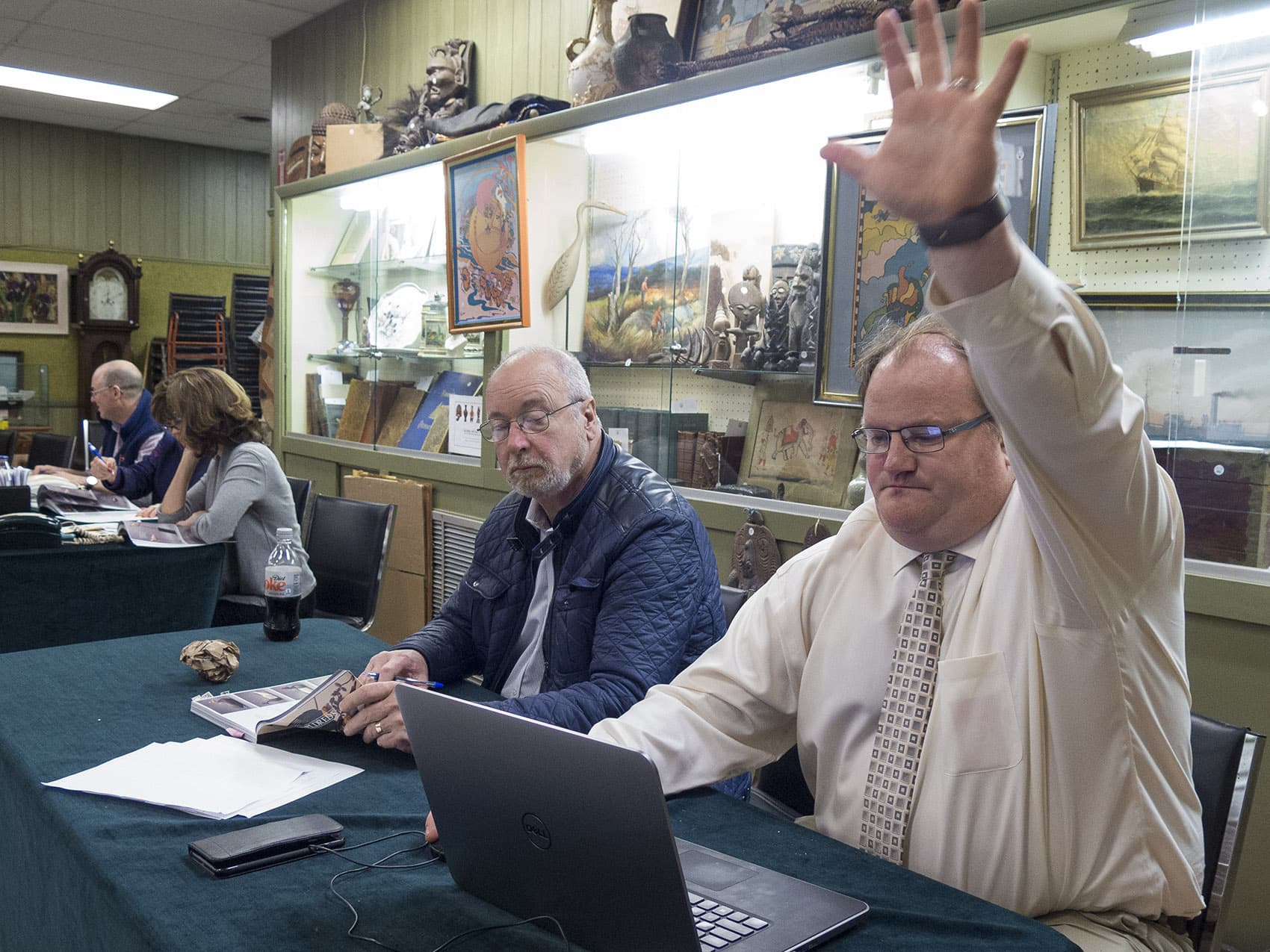 Josh Eldred plays the role of online bidder during a fast-moving auction of hand-carved water bird decoys. (Andrea/Shea)