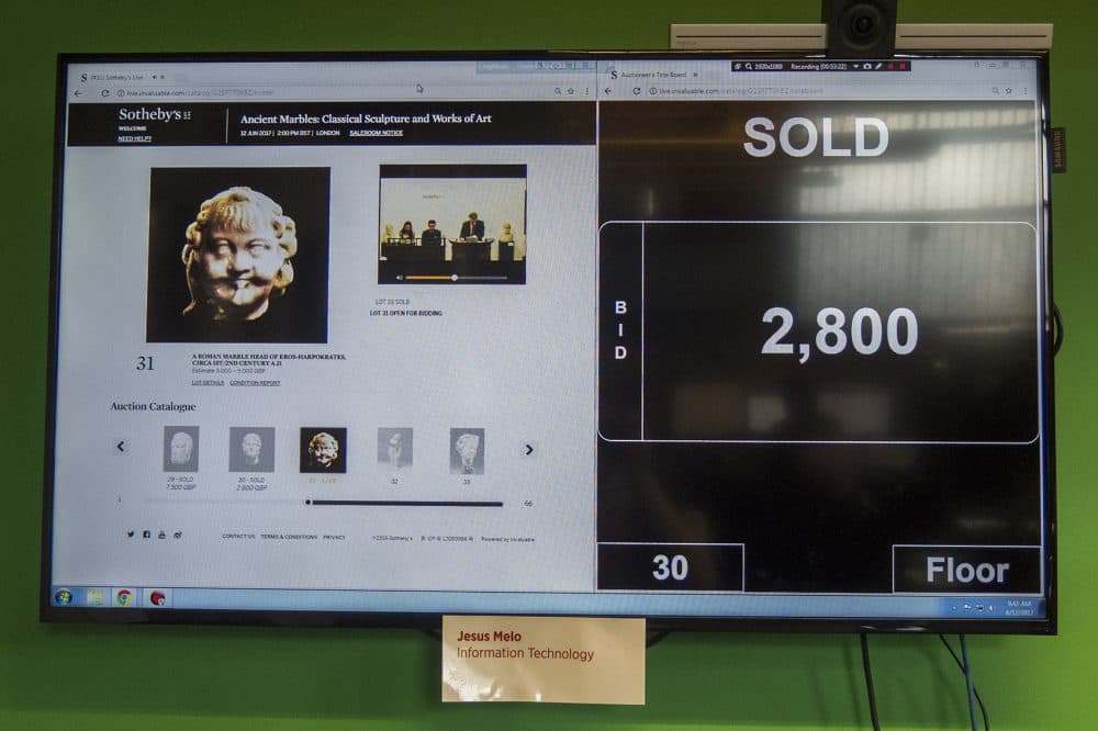 One of the big flat screens in Invaluable's office streams live from a Sotheby's auction in London. (Andrea Shea/WBUR)