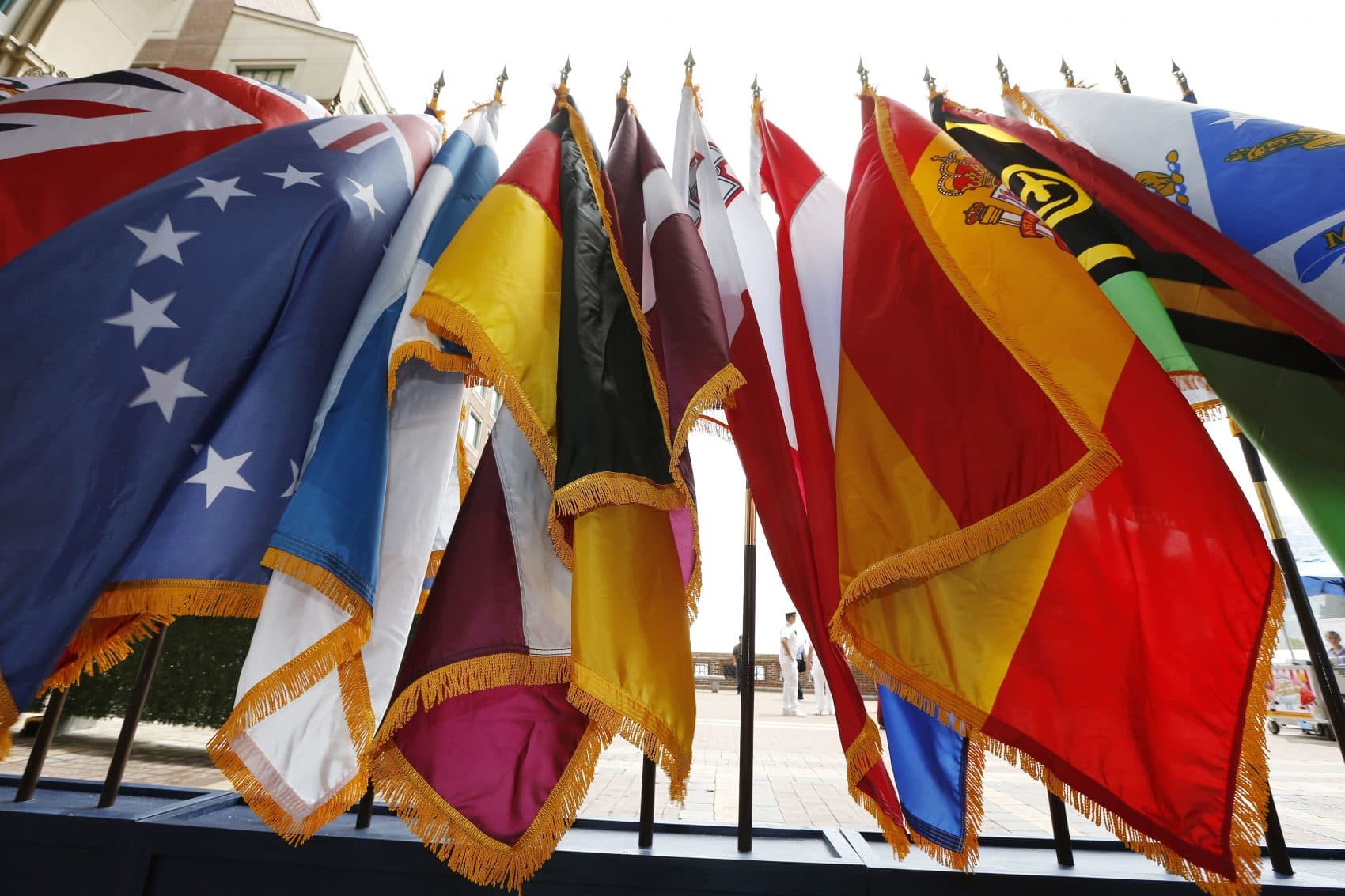 Flags for a backdrop during opening ceremonies for the Sail Boston tall ships event on Friday in Boston. (Michael Dwyer/AP)