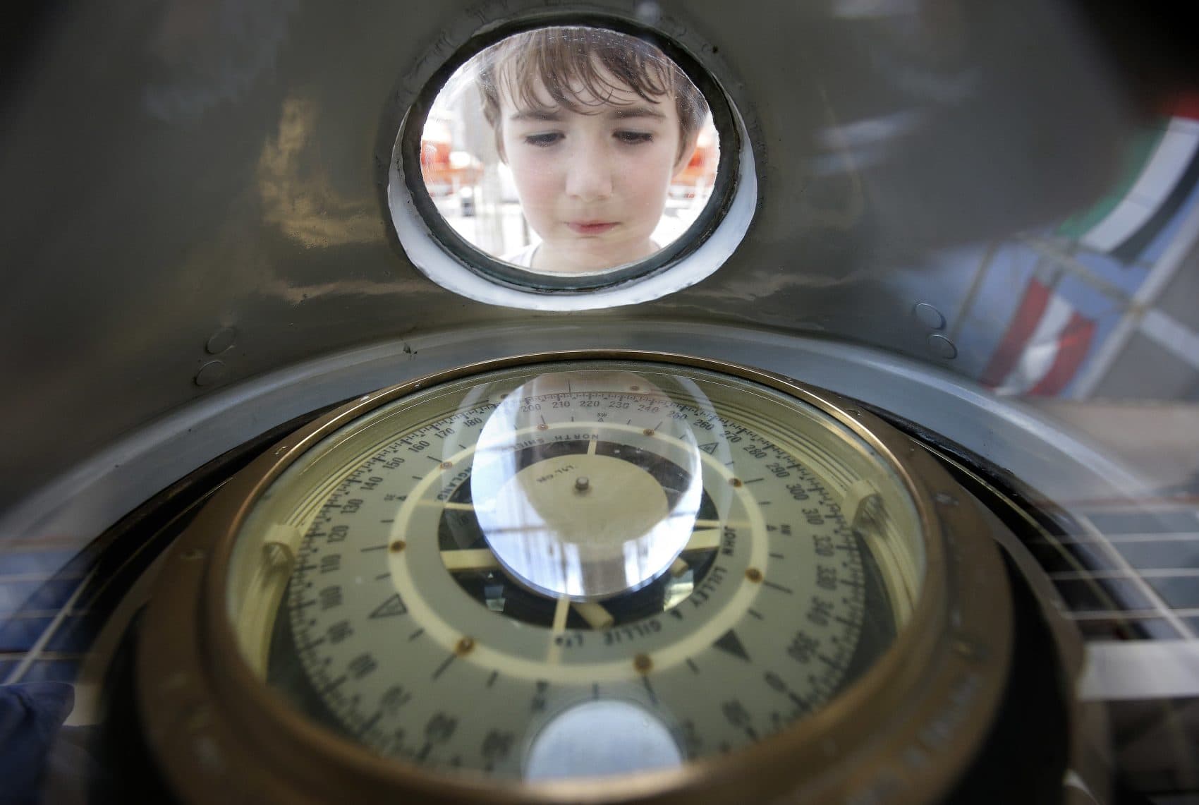 Sean Sullivan, 8, of Wellesley, Mass., examines a compass aboard the Peruvian Navy tall ship Union, which was open to the public to visitors on Sunday. (Steven Senne/AP)