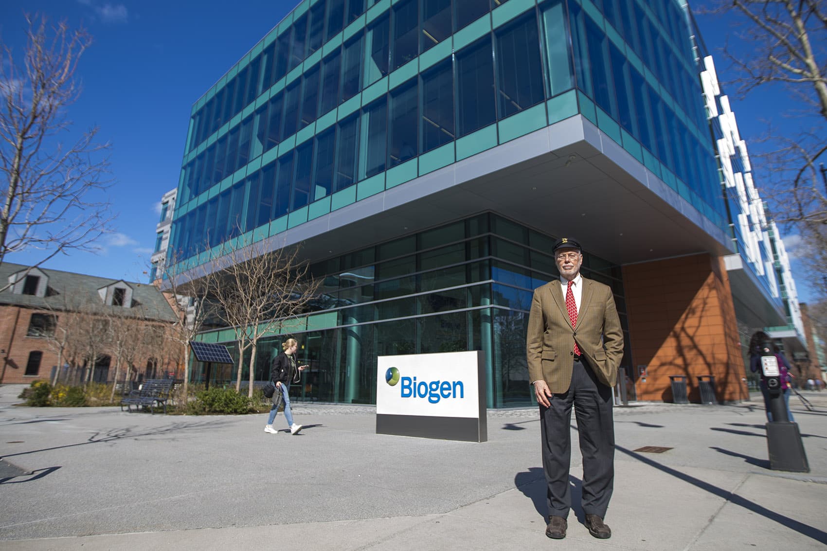 Biogen co-founder Phillip Sharp standing in front of the company's building in Cambridge. (Jesse Costa/WBUR)