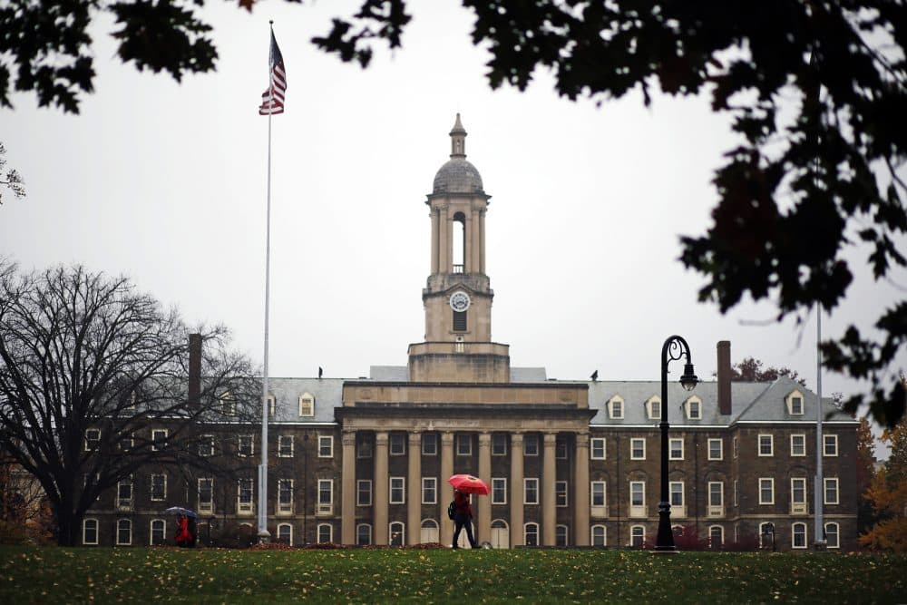 A Penn State student walks past Old Main on the Penn State main campus in State College, Pa., in 2015. (Gene J. Puskar/AP)