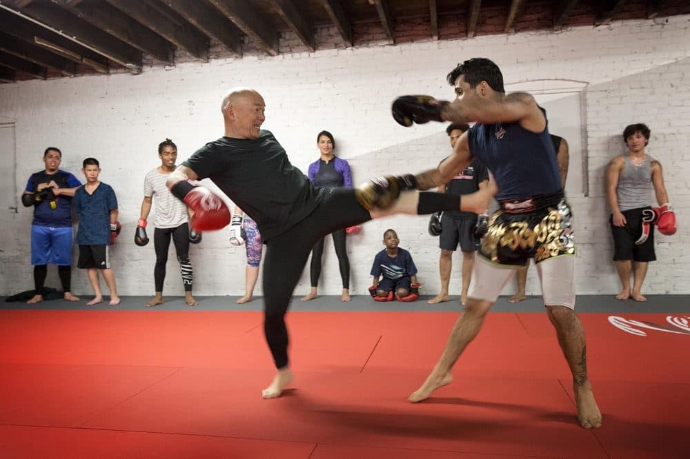 Coach Dave Moy, left, lands a kick on William Graustuck at Level Ground. (Robin Lubbock/WBUR)