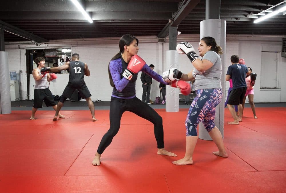 Level Ground founder Alexandra Fuller, left, trains with Alisandra Quiñones, now a three-year veteran of MMA. (Robin Lubbock/WBUR)