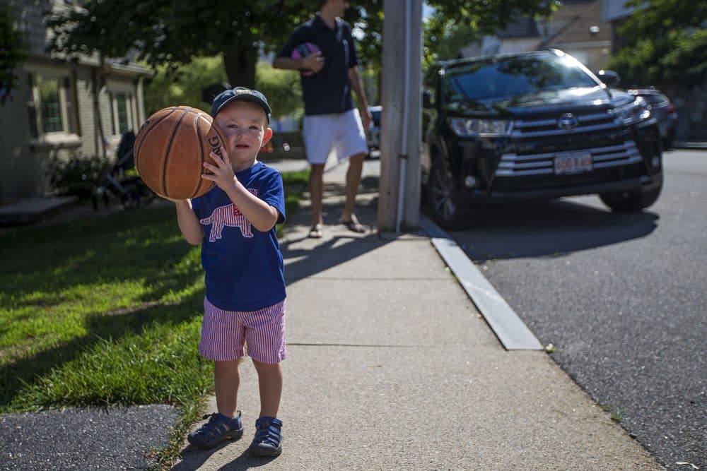 Two-and-a-half year old Robbie Klein has hemophelia, a medical condition in which the ability of the blood to clot is reduced. Here Robbie prepares to shoot some hoops with his father Joel. (Jesse Costa/WBUR)