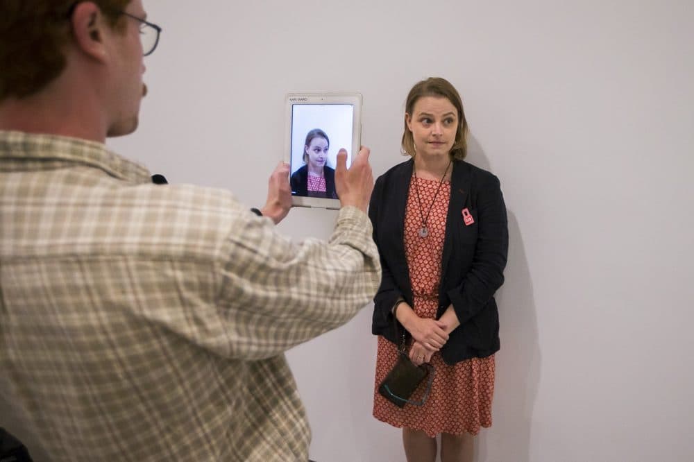 Andrea Goetschius getting her photograph taken for her documentation as part of the interactive &quot;Naturalization Drawing Table.&quot; (Jesse Costa/WBUR)