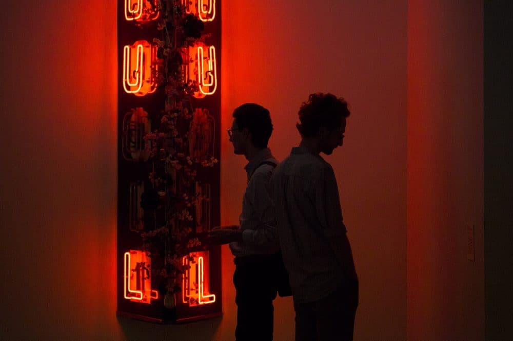 Two museum patrons view the neon sign &quot;Radha Liquorsoul.&quot; (Jesse Costa/WBUR)