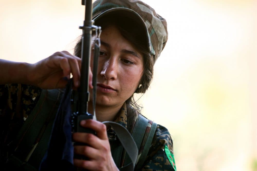 A fighter from the Kurdish female Women's Protection Units adjusts the crosshairs on her rifle during a training exercise in the northeastern Syrian Kurdish town of Derik, on June 1, 2017. (Delil Souleiman/AFP/Getty Images)
