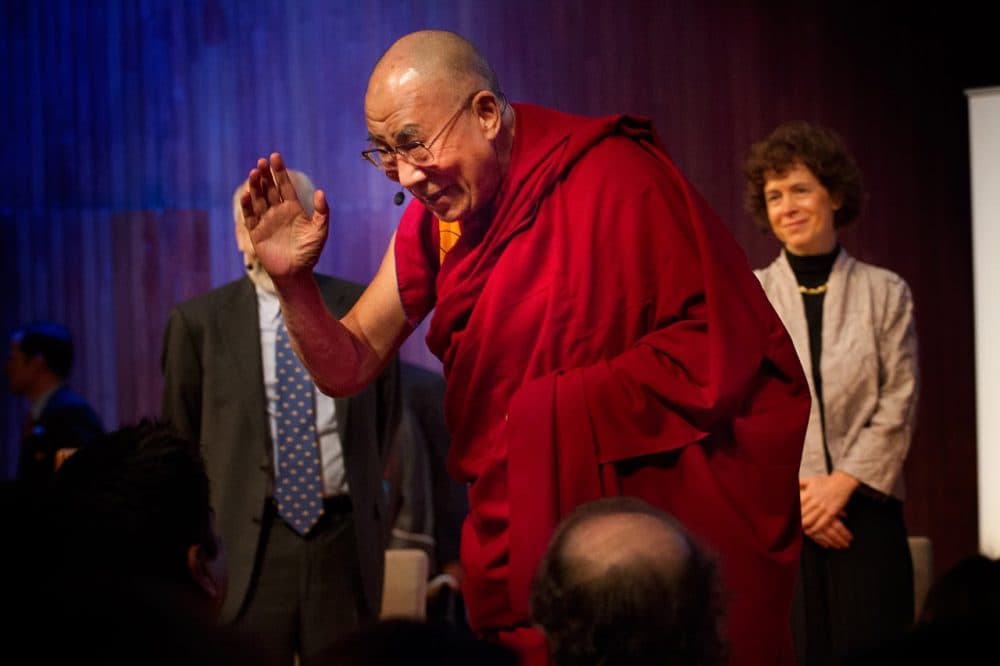 Tibetan exiled spiritual leader the Dalai Lama waves as he takes the stage for the &quot;Ethics, Economy and Environment Panel&quot; at the Global Systems 2.0 Conference at MIT on October 15, 2012. (Jesse Costa/WBUR)