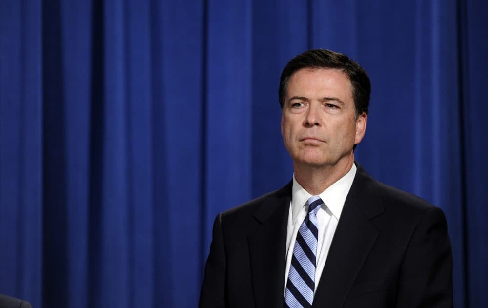 FBI Director James Comey listens during a news conference announcing a deal between the U.S. government and French bank BNP Paribas at the Justice Department in Washington, Monday, June 30, 2014. The U.S. government and French bank BNP Paribas have agreed to a settlement over alleged sanctions violations that would require the bank to plead guilty, pay almost $9 billion in penalties and face other sanctions. (AP Photo/Susan Walsh)