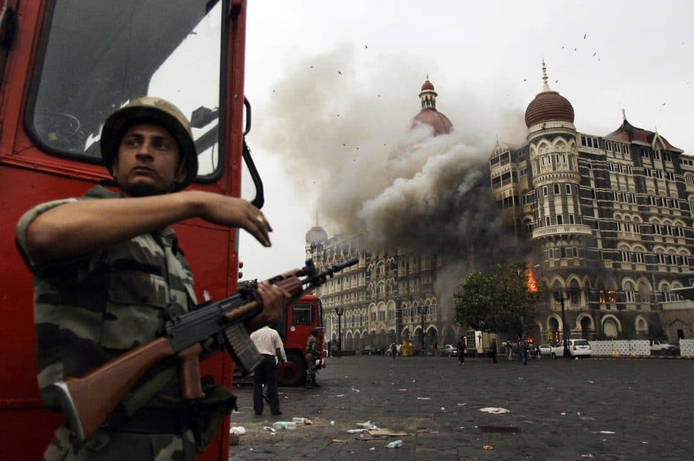In this 2008 file photo, an Indian soldier takes cover as the Taj Mahal hotel in Mumbai burns during a gun battle between Indian military and militants. Pakistani-American David Headley helped the 2008 attack. (David Guttenfelder/AP)