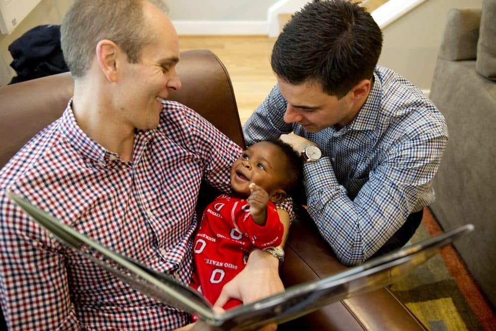 Gregg Pitts, left, and Brooks Brunson read to their son, Thomas Brunson-Pitts, 6 months, before heading to work in the morning at their home in Washington, on May 19, 2016. (Jacquelyn Martin/AP)
