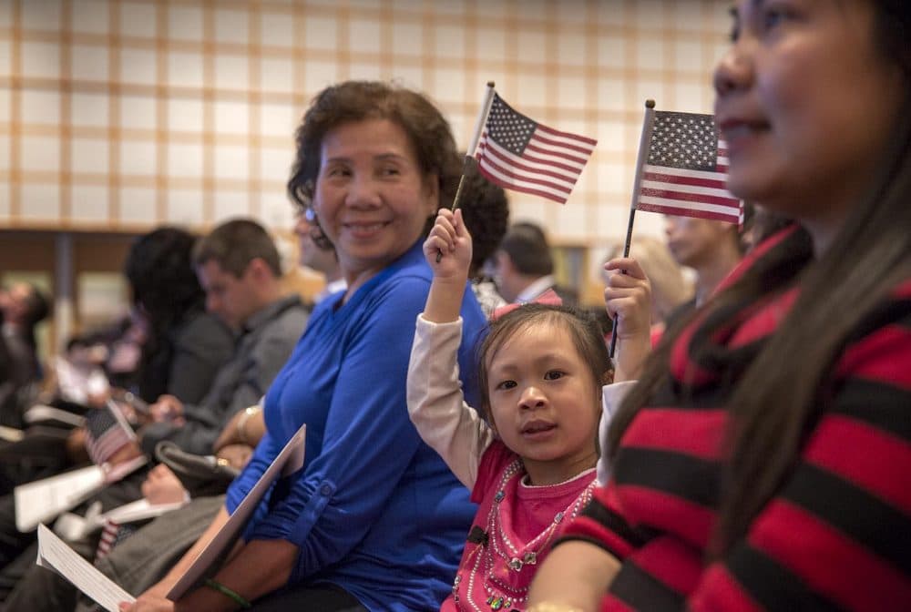 Annie Lau, 4, waves flags at her grandmother's naturalization ceremony at the JFK Library in Boston in March 2017. (Robin Lubbock/WBUR)