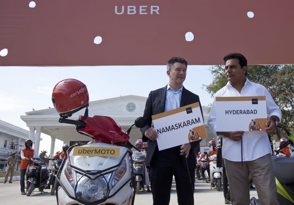 Uber CEO Travis Kalanick, center, poses with Telangana state minister for Information and Technology during the launch of Uber's bike-sharing product, uberMOTO, in Hyderabad, India, Dec., 2016. (Mahesh Kumar A./AP)