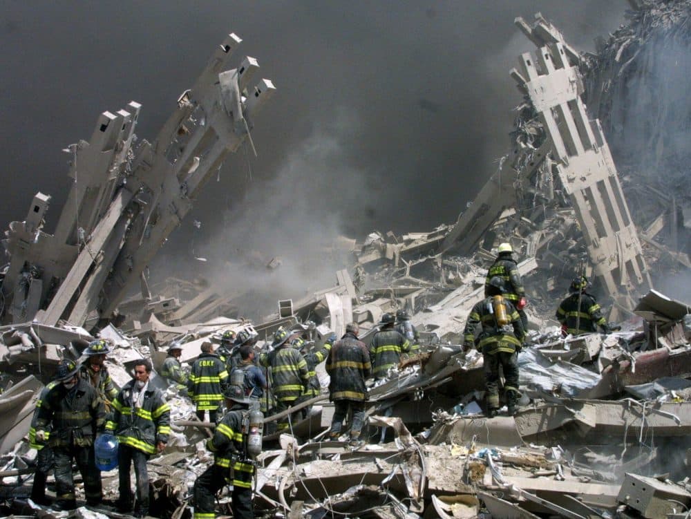 Firefighters make their way through the rubble after two airliners crashed into the World Trade Center in New York on Sept. 11, 2001. (Shawn Baldwin/AP)