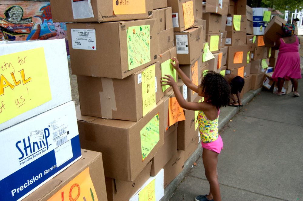 At Wee The People's &quot;Protestival&quot; during the JP Porchfest, kids build a giant wall with boxes at Boston's Mozart Park before tearing them down for the finale. (Greg Cook)