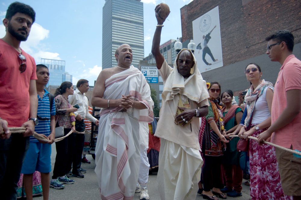 Smashing a coconut for an auspicious beginning to the Festival of Chariots — or Ratha Yatra. (Greg Cook/WBUR)