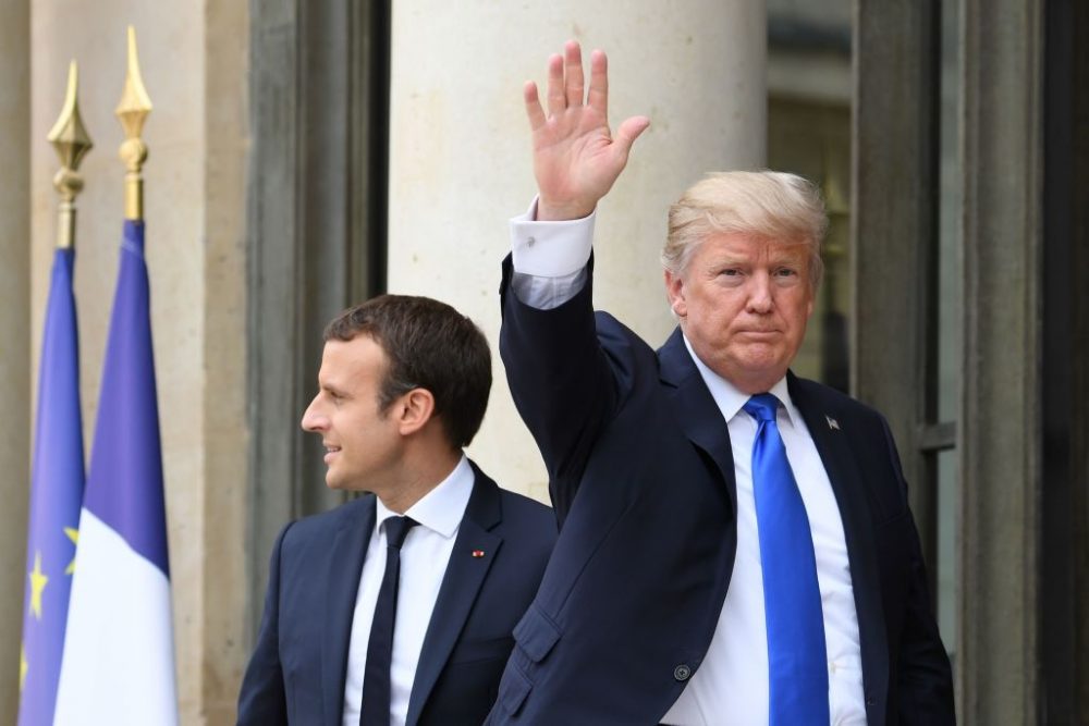 U.S. President Donald Trump (right) waves as he is greeted by French President Emmanuel Macron ahead of their meeting at the Elyse Palace in Paris on July 13, 2017. (Alain Jocard/AFP/Getty Images)