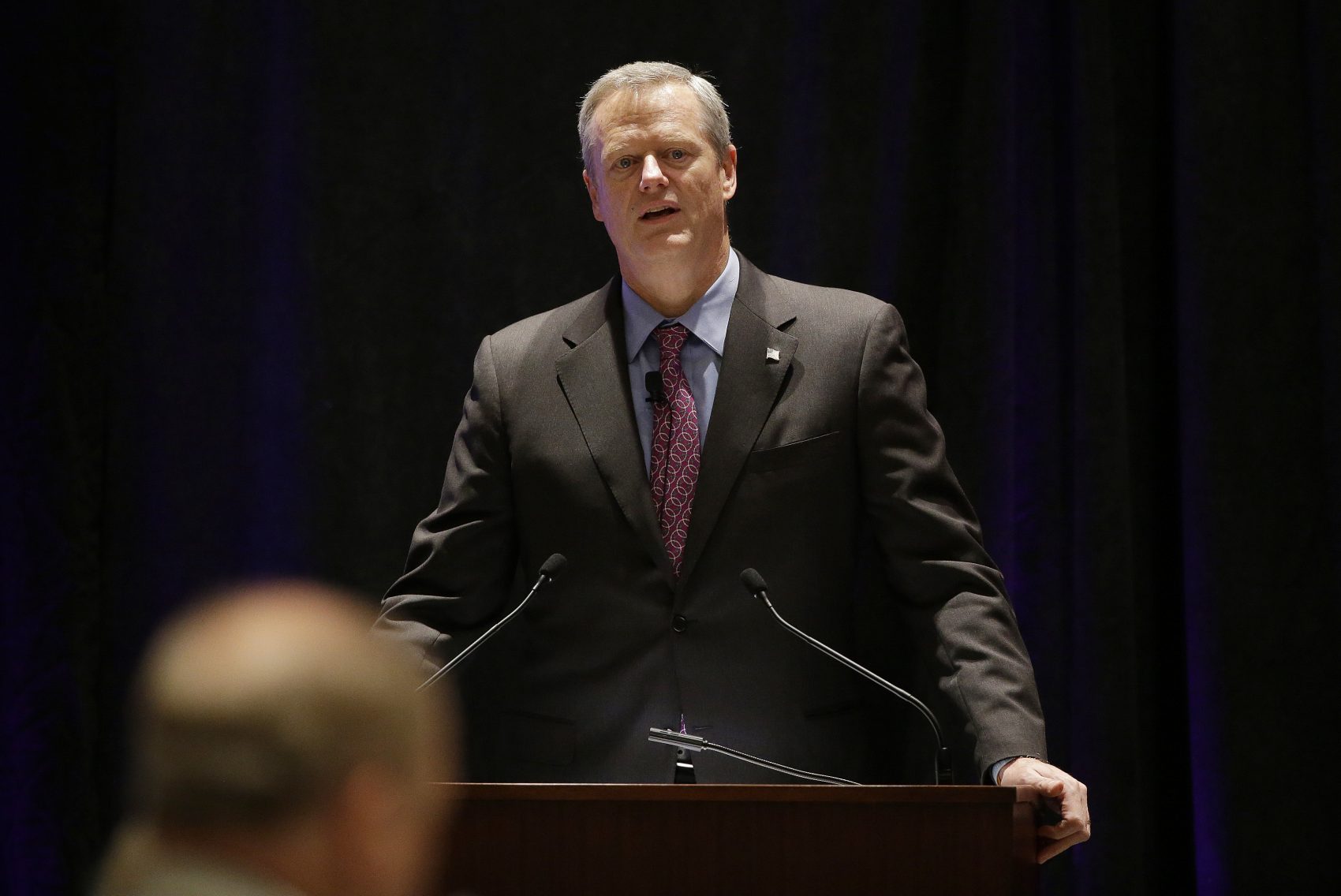 Baker is essentially using the threat of future spending reductions as leverage for a deal over MassHealth reforms. (Stephan Savoia/AP)
