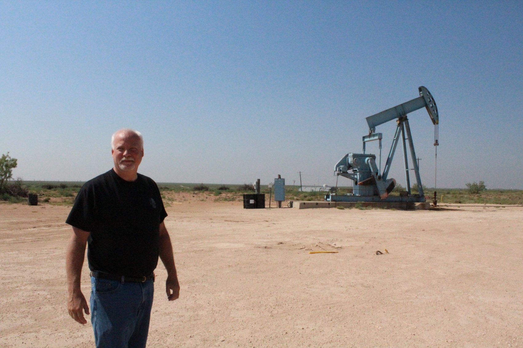 Midland County Sergeant John Henry walks near a pumpjack. (Marfa Public Radio)