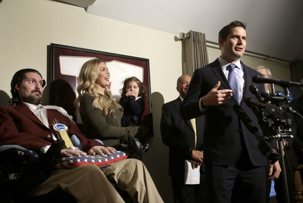 U.S. Rep. Seth Moulton, D-Mass., right, faces reporters as former Boston College baseball captain Pete Frates, left, and his wife Julie, center, and daughter Lucy, look on during ceremonies held to honor Frates with the 2017 NCAA Inspiration Award, Tuesday, Dec. 13, 2016, at their home in Beverly, Mass. (Steven Senne/AP)