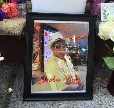 A photo of Andres Cruz amid a memorial outside his AC Hardware store (Anthony Brooks/WBUR)