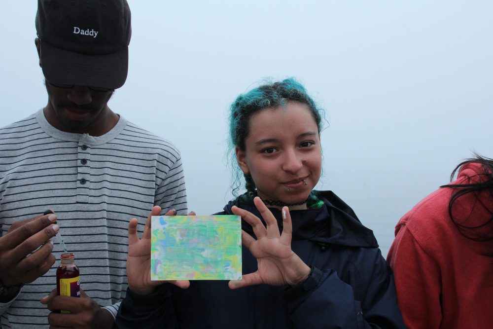Jasline Gonzalez holds a homemade postcard. (Courtesy of World Ocean School)