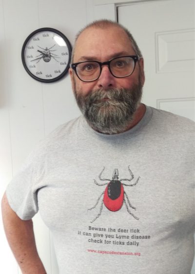 Barnstable County tick project coordinator Larry Dapsis in his tick T-shirt. (And note the clock in the background.) (Courtesy of Barnstable County)
