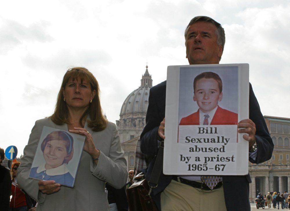 Advocates for victims of clergy sex abuse, Barbara Blaine from Chicago, Ill., and Bill Gately, from Boston, Mass., hold pictures of themselves at the age of 12 and 14 respectively when they were allegedly sexually abused by clergymen, at a protest near St. Peter's Square in Rome in 2005. (Alessandra Tarantino/AP)