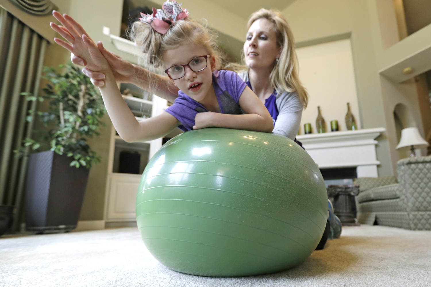 Stacey English, right, works on balance and core strength with her 7-year-old daughter, Addison, in Houston on Friday, June 23, 2017. Texas children with special needs like Addison have lost critical services since the state implemented $350 million in Medicaid cuts to speech, occupational, and physical therapy in December. (David J. Phillip/AP)