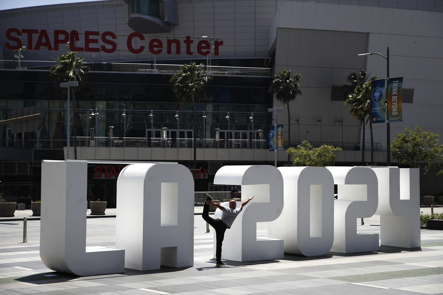 Yoga instructor Michael Phillip poses with a Los Angeles 2024 sign outside Staples Center, Friday, May 12, 2017, in Los Angeles. (Jae C. Hong/AP)