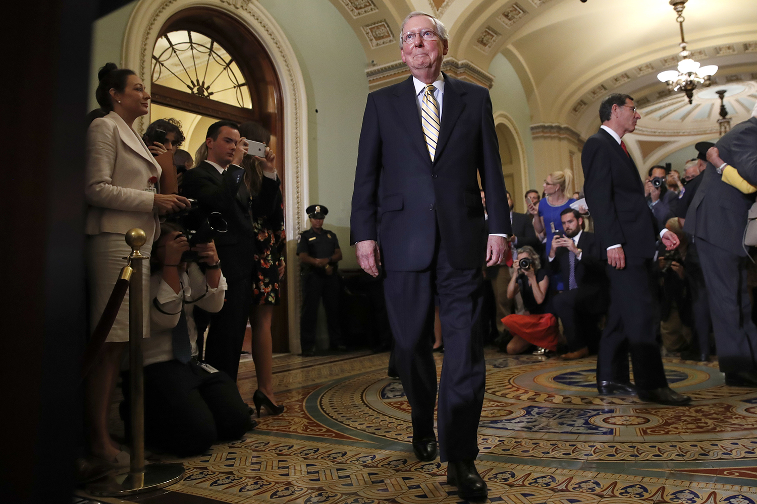 Senate Majority Leader Mitch McConnell of Ky., center, approaches the podium to talk to reporters on Capitol Hill in Washington, Tuesday, July 25, 2017, after Vice President Mike Pence broke a 50-50 tie to start debating Republican legislation to tear down much of the Obama health care law. (Jacquelyn Martin/AP)
