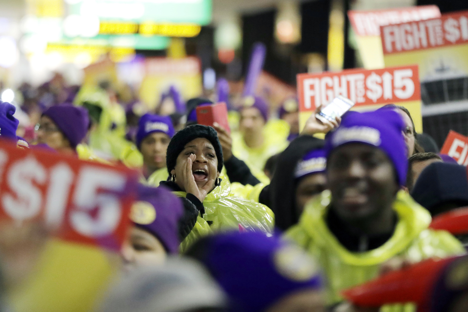 A woman shouts while marching with service workers asking for $15 minimum wage pay during a rally at Newark Liberty International Airport, Tuesday, Nov. 29, 2016, in Newark, N.J. The event was part of the National Day of Action to Fight for $15. (Julio Cortez/AP)