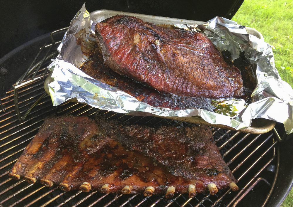 Kathy's Texas-style brisket (top) and dry-rubbed pork ribs on the grill. (Kathy Gunst for Here &amp; Now)