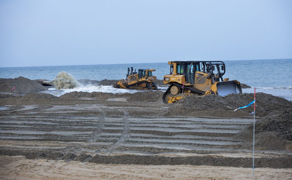 On Buxton Beach, bulldozers move sand being piped in from a dredge ship 2 miles off shore. The so-called &quot;beach nourishment&quot; project costs over $7 million a mile -- $22 million in public money in all. The engineers guarantee a life of five years, but Stan Riggs says the sand is generally gone in two. (Jesse Costa/WBUR)