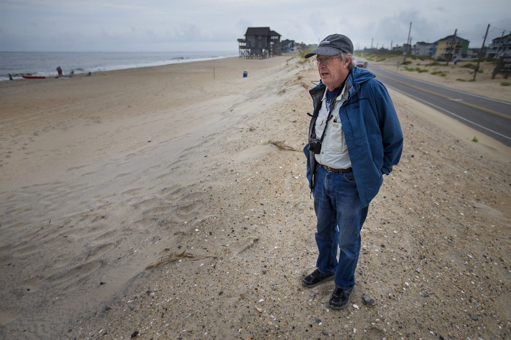 Stanley Riggs, of East Carolina University, stands on the edge of the Rodanthe Beach and Highway 12, where the Outer Banks are particularly prone to storm damage. (Jesse Costa/WBUR)