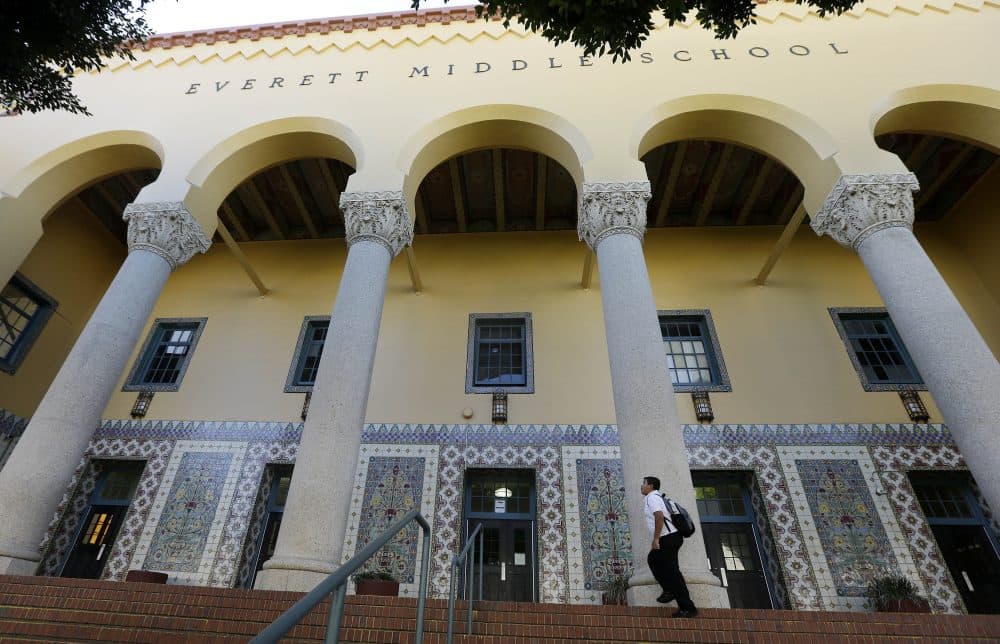 The California legislature is considering a bill which would require all middle and high schools to open at 8:30 a.m. or later by 2020. Pictured: An unidentified boy walks outside Everett Middle School in San Francisco in 2015. (Jeff Chiu/AP)